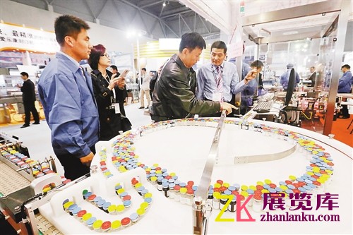 参展商正在向观众展示先进的制药机械。
